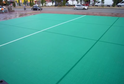 grüner Sportboden, weiße Mittellinie, Expansionsleisten als Spielfeld-Markierungen,